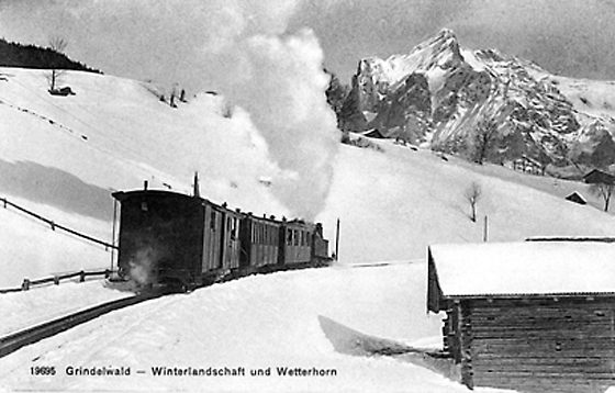 Ein BOB-Dampfzug an der Rothenegg, kurz vor Grindelwald. Vor hundert Jahren kamen immer häufiger Tagesausflügler. Am Berchtoldstag 1906 beförderte die Dampfbahn in mehreren Fahrten von Interlaken her 300 schneehungrige Fahrgäste ins verschneite Tal.