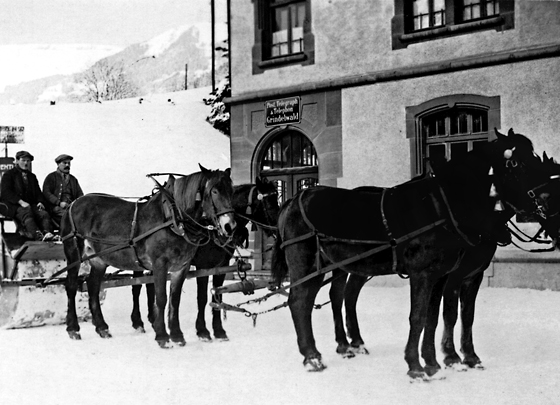 Grindelwalds Schneeräumung 1910 vor der neuen Post: Ein Vierspänner mit einer Schneewalze.