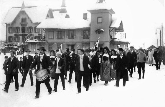 Empfang von Grindelwalds «Skihelden» beim Bahnhof. Die Militärpatrouille von Leutnant Hans Bernet zu Stotzhalten, dem späteren Gemeindepräsidenten, mit dem Siegerpokal. Sie siegten 1911 in Sankt Moritz und wurden in einem Umzug in zackigem Schritt durchs Dorf gefeiert.